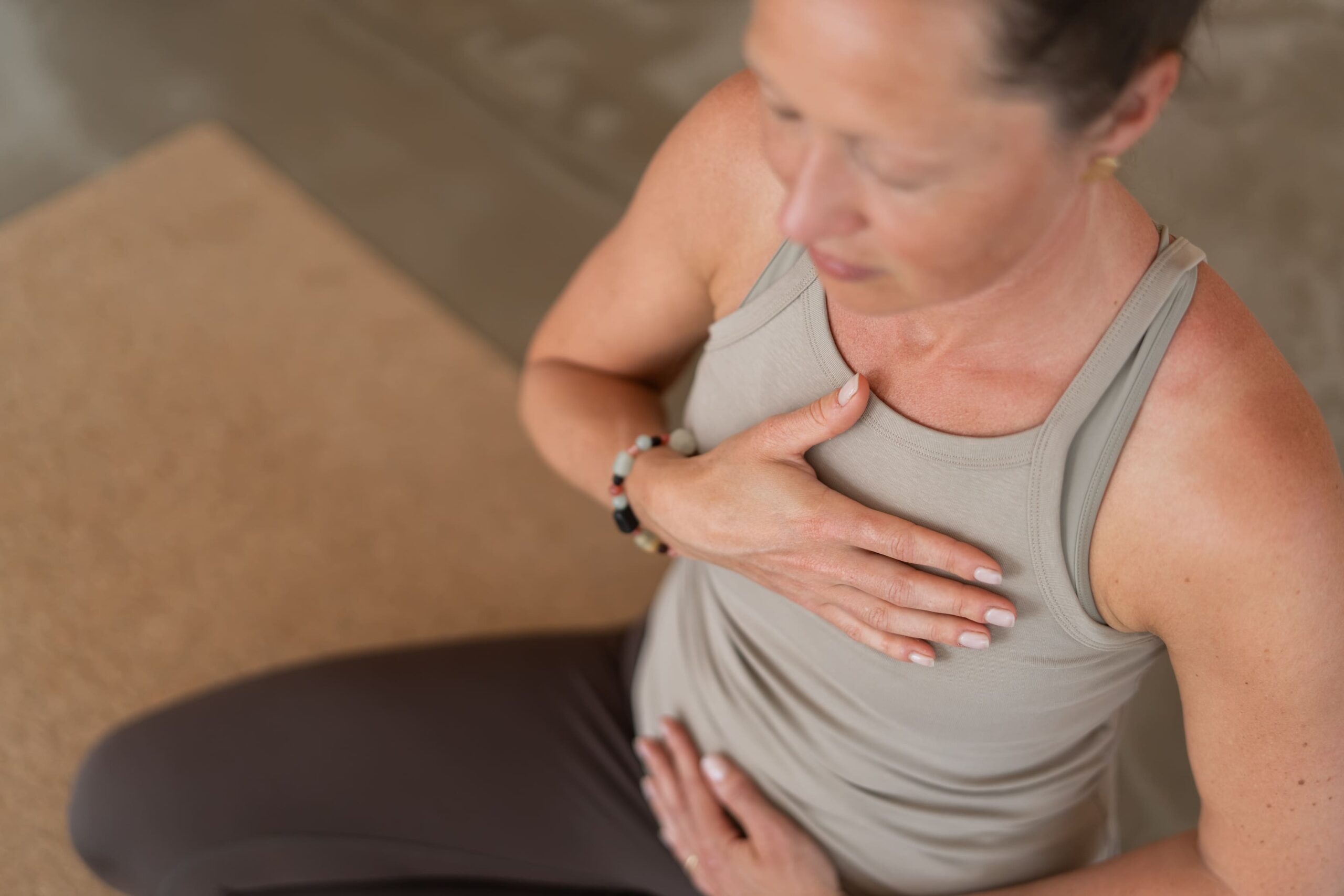 Yogalærer arbejder med åndedræt og kropsbevidsthed under yoga.